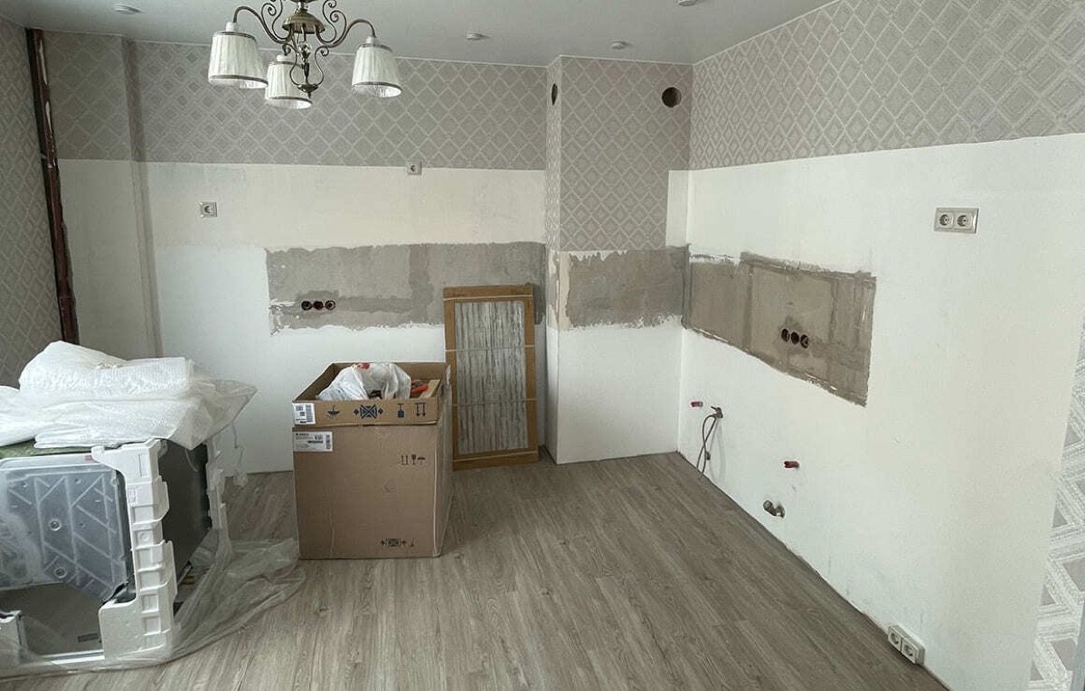 Комната после демонтажа старой кухни: коробки с техникой, голые стены